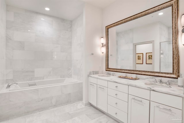 bathroom featuring vanity and a relaxing tiled tub