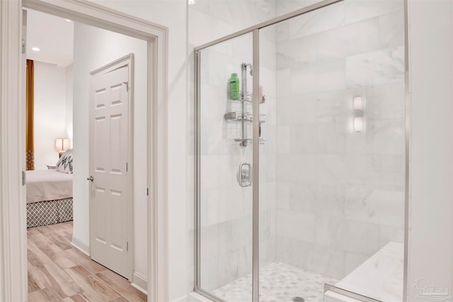 bathroom featuring wood-type flooring and a shower with shower door