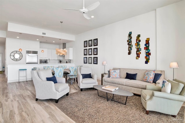 living room with light wood-type flooring and ceiling fan