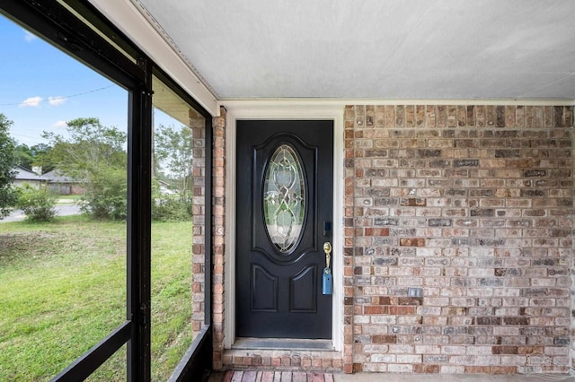 view of exterior entry with a yard