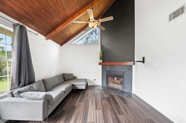 living room featuring beam ceiling, ceiling fan, a tile fireplace, and wooden ceiling