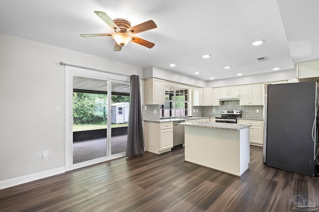 kitchen with visible vents, decorative backsplash, dark wood-style floors, stainless steel appliances, and under cabinet range hood