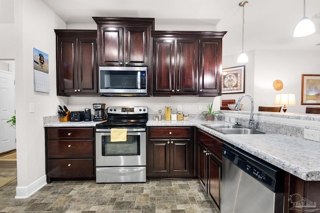 5282 Parkside Dr, Pace, FL 32571 - kitchen featuring appliances with stainless steel finishes, light countertops, stone finish floors, a peninsula, and decorative light fixtures