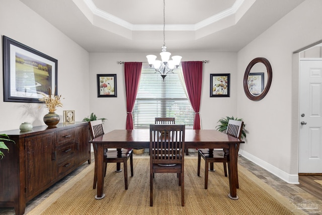 5282 Parkside Dr, Pace, FL 32571 - dining space featuring a chandelier, a tray ceiling, crown molding, and light wood-type flooring