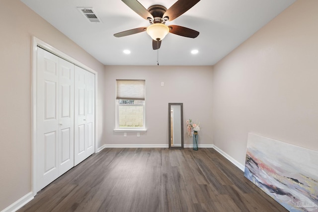 unfurnished bedroom with ceiling fan, a closet, and dark hardwood / wood-style flooring