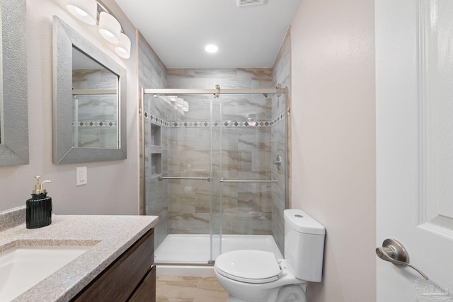 bathroom featuring an enclosed shower, vanity, and toilet