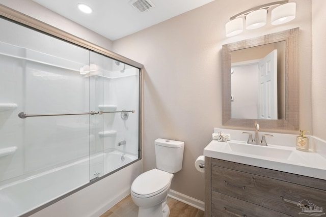 full bathroom featuring wood-type flooring, bath / shower combo with glass door, vanity, and toilet