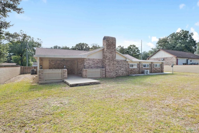 rear view of house with a lawn and central AC