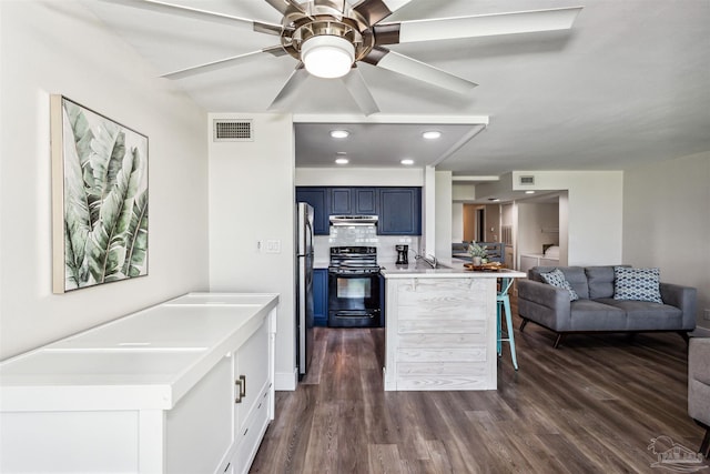 kitchen with blue cabinets, stainless steel fridge, kitchen peninsula, black electric range, and a breakfast bar area