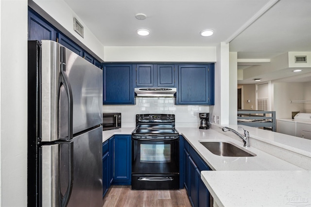 kitchen featuring sink, black appliances, blue cabinetry, independent washer and dryer, and light hardwood / wood-style floors