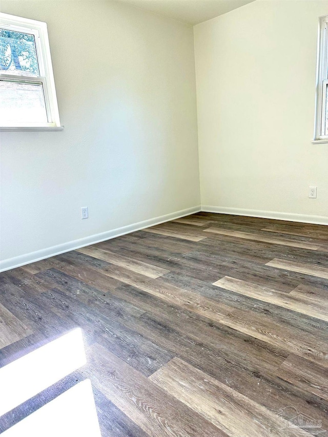 unfurnished room featuring baseboards and wood finished floors