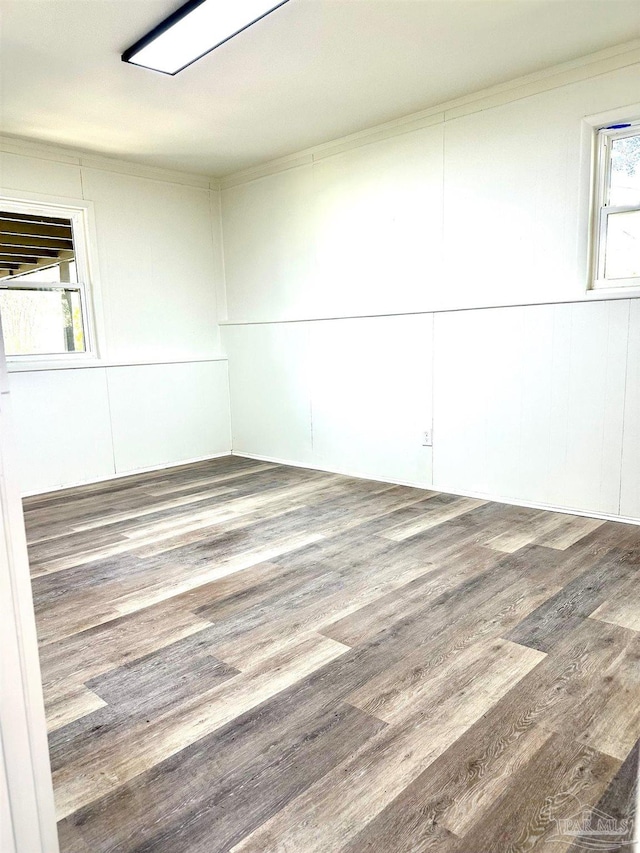 spare room with wood finished floors and ornamental molding