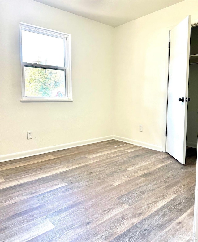 spare room featuring wood finished floors and baseboards