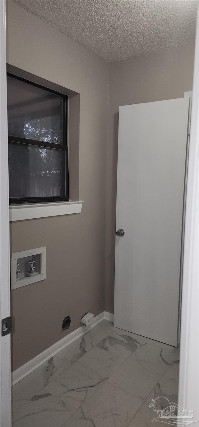 washroom with washer hookup and a textured ceiling