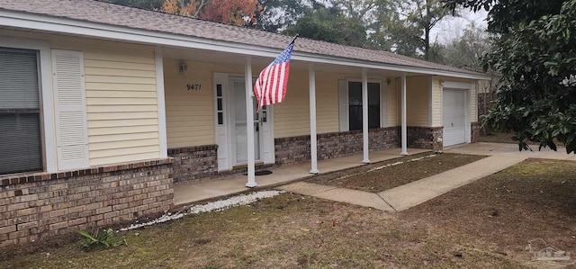 view of exterior entry with a porch and a garage