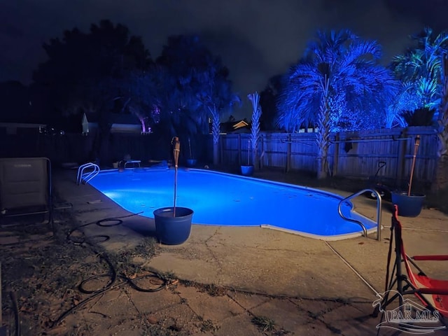 1515 Mariners Cir, Gulf Breeze, FL 32563 - pool at night with a fenced backyard and a patio