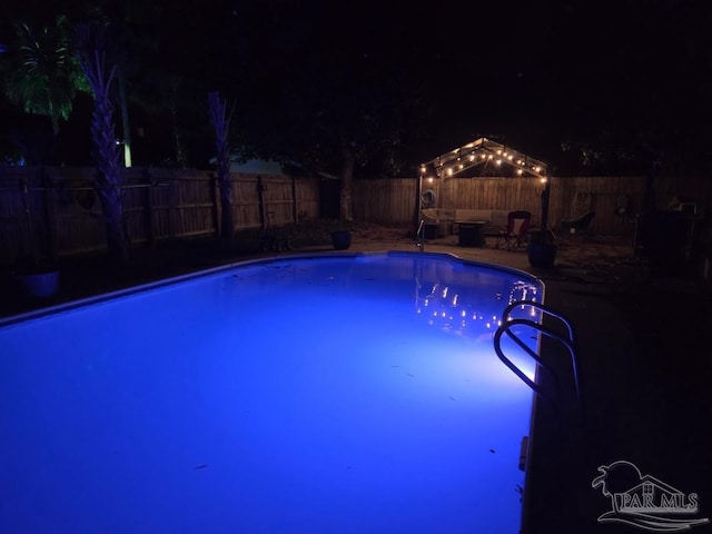 1515 Mariners Cir, Gulf Breeze, FL 32563 - pool at night with a fenced backyard and a patio
