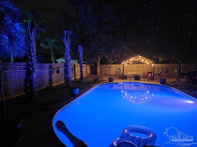 1515 Mariners Cir, Gulf Breeze, FL 32563 - pool at night with a fenced backyard and a patio area