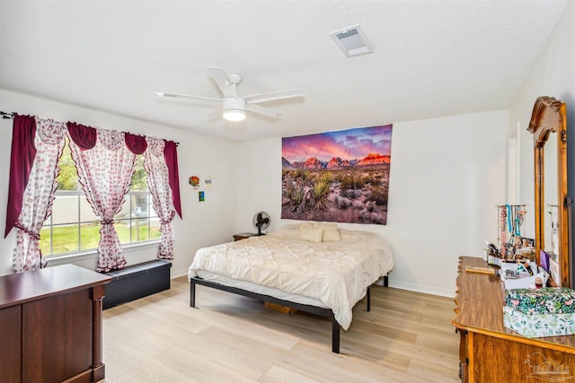 bedroom with light wood-style floors, baseboards, and visible vents