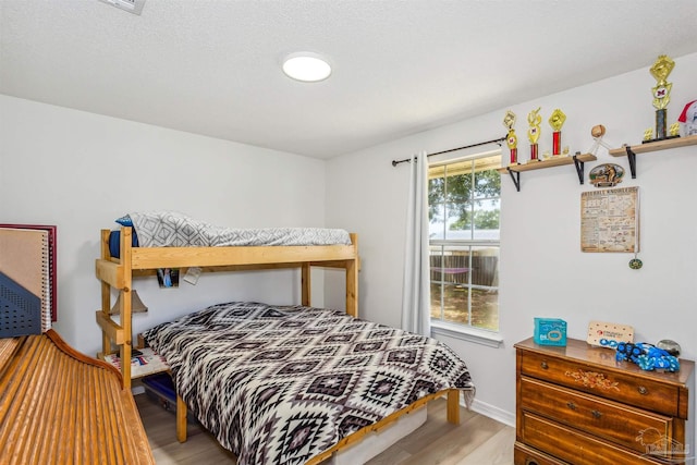 bedroom with wood finished floors and baseboards