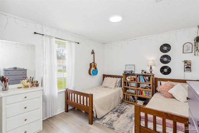 bedroom with light wood finished floors and multiple windows