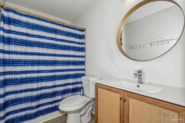 bathroom featuring toilet, a shower with shower curtain, a textured ceiling, and vanity