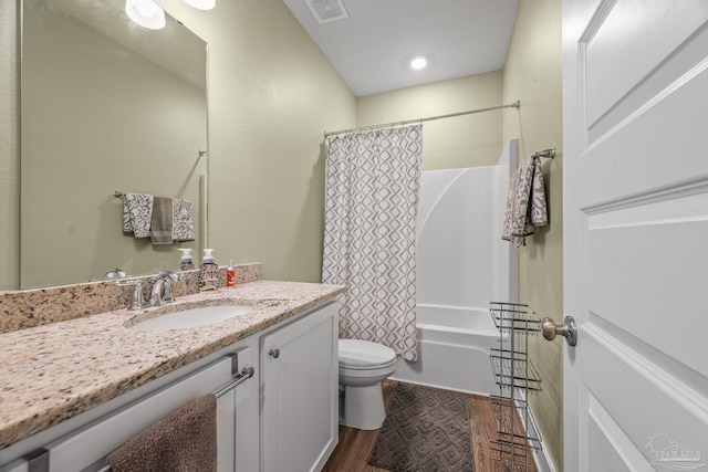 full bathroom featuring toilet, wood finished floors, vanity, visible vents, and shower / tub combo with curtain