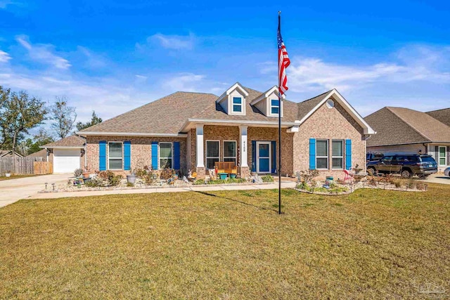 view of front of property featuring brick siding, roof with shingles, covered porch, a front yard, and fence