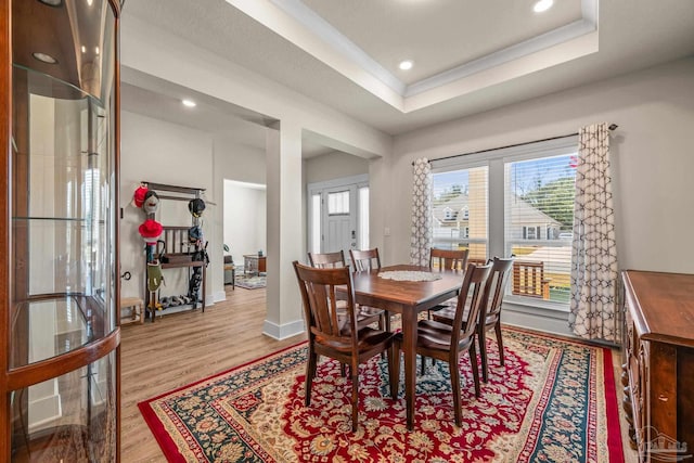 dining area with recessed lighting, a raised ceiling, baseboards, and wood finished floors