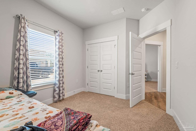 bedroom featuring carpet floors, a closet, visible vents, and baseboards