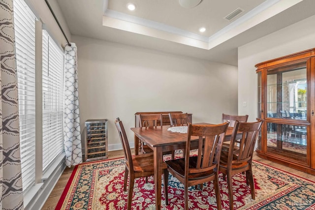 dining area with wine cooler, recessed lighting, wood finished floors, visible vents, and a raised ceiling