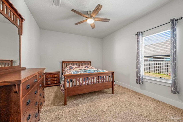 bedroom with baseboards, a ceiling fan, visible vents, and light colored carpet