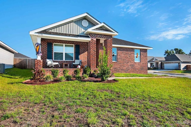 view of front facade featuring a garage, a front yard, and central AC