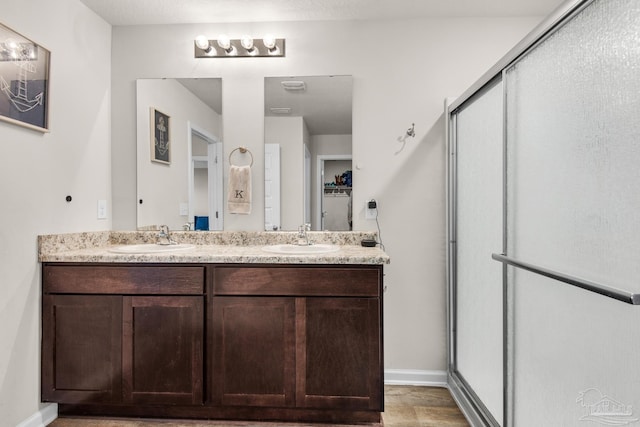 bathroom with vanity, an enclosed shower, and wood-type flooring