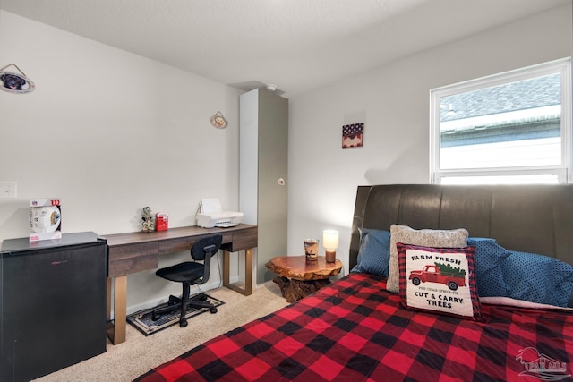 bedroom featuring black refrigerator and carpet