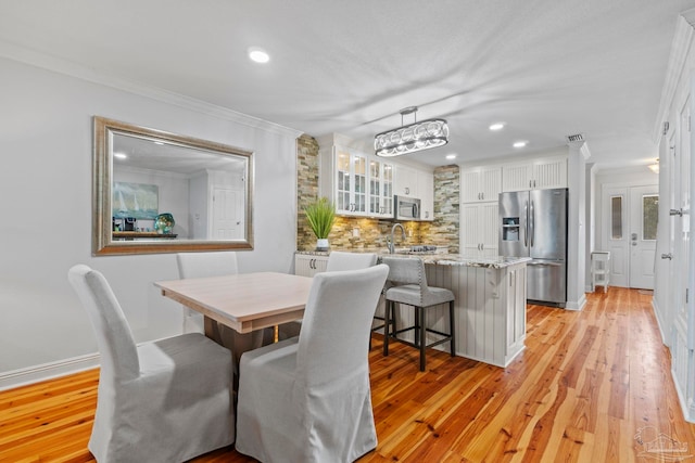 dining space with recessed lighting, visible vents, baseboards, ornamental molding, and light wood finished floors