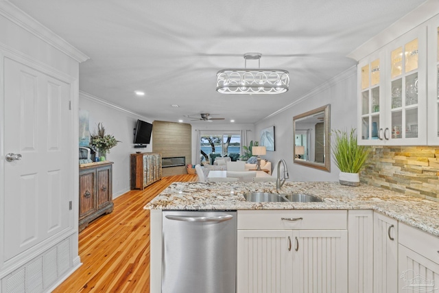 kitchen with dishwasher, a peninsula, a sink, and crown molding