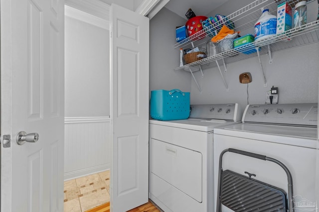 laundry area with laundry area, washing machine and dryer, and wainscoting