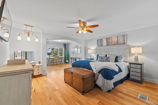 bedroom featuring ornamental molding, arched walkways, visible vents, and light wood-style flooring