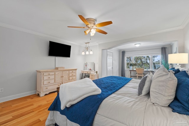 bedroom with light wood-type flooring, arched walkways, crown molding, and baseboards