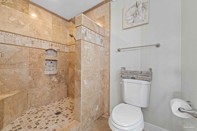 bathroom featuring baseboards, tiled shower, and toilet