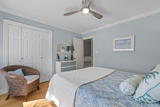 bedroom featuring light wood finished floors, a closet, a ceiling fan, and crown molding