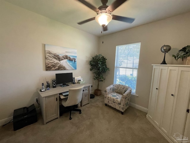 office space with baseboards, ceiling fan, and light carpet