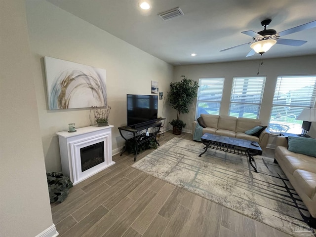 living area featuring ceiling fan, baseboards, visible vents, and wood finished floors
