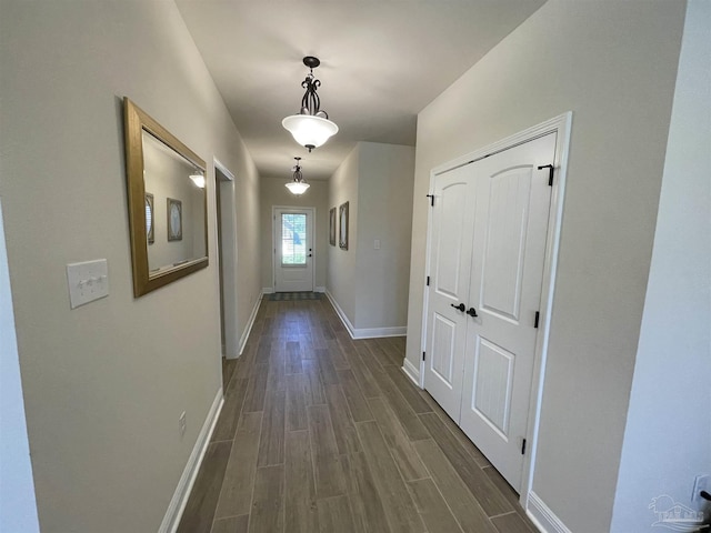 hallway with baseboards and dark wood finished floors