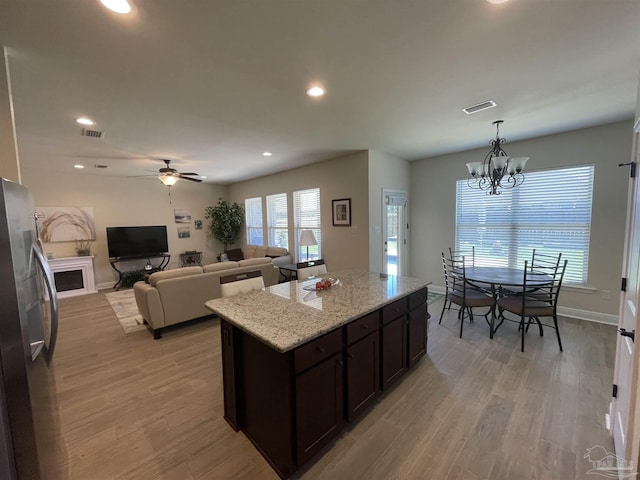 kitchen featuring freestanding refrigerator, dark brown cabinets, recessed lighting, and visible vents