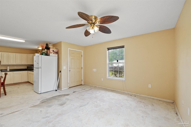 kitchen with ceiling fan, a textured ceiling, and white fridge