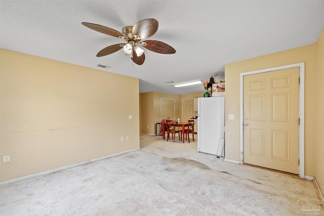 carpeted spare room featuring ceiling fan and a textured ceiling