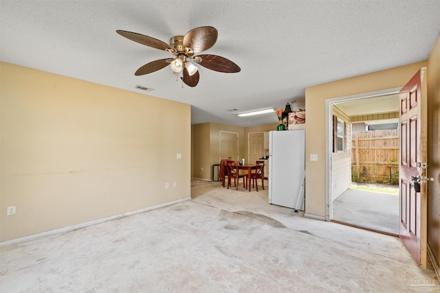 carpeted spare room with ceiling fan and a textured ceiling