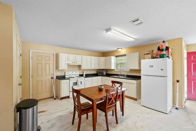 kitchen featuring a textured ceiling, white appliances, and sink